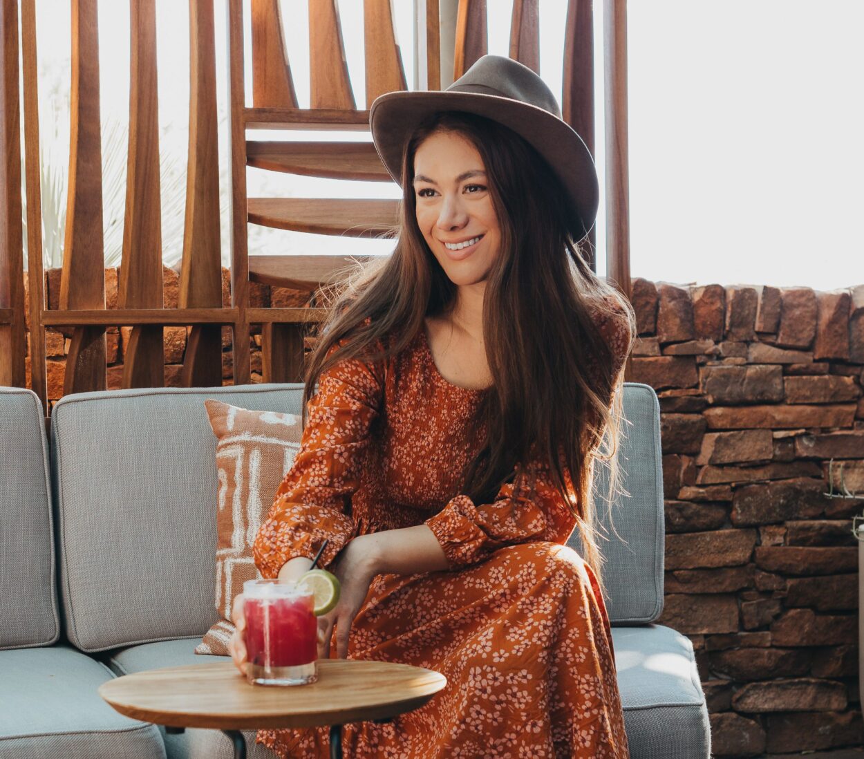 woman with cocktail sat near outdoor fire pit area