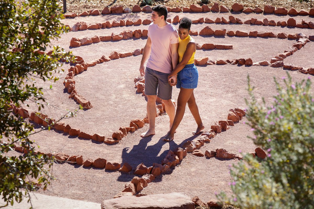 couple walking hand in hand through lawn area