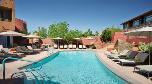 length view of pool with day sun loungers and shaded areas