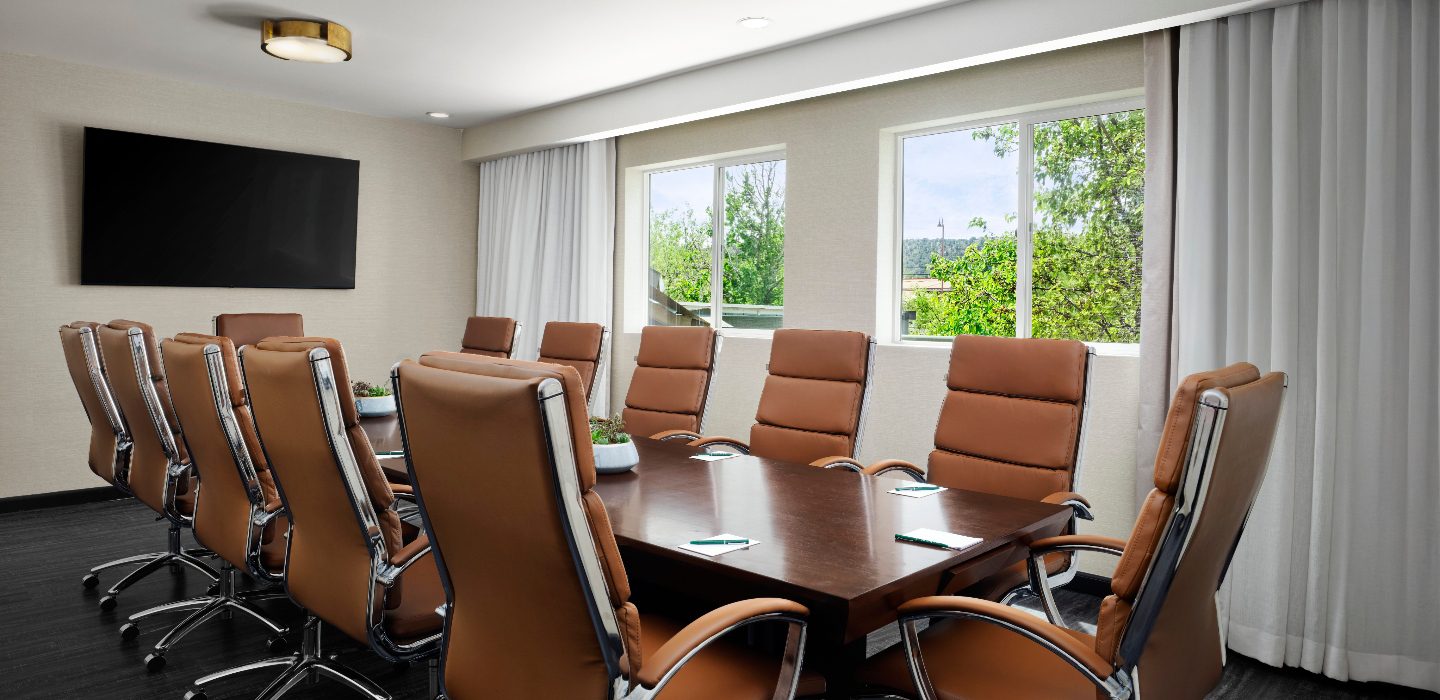 Image of brown leather chairs surrounding an office table